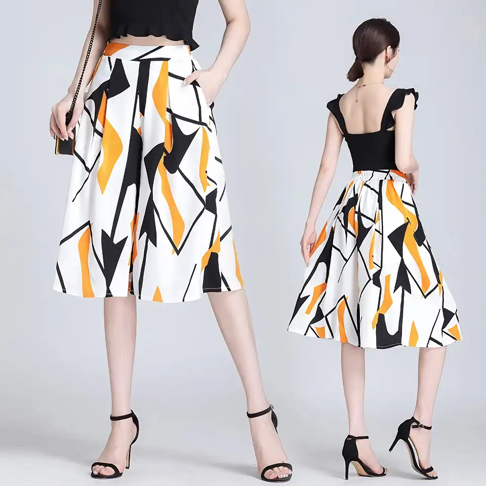 Stylish wide-leg pants with bold black, white, and orange abstract print, perfect for fashionable women. Comfortable fit with high waist and side pockets, ideal for casual or chic events.