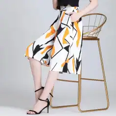 Stylish women's high-waisted skirt with bold geometric print, paired with black high heels, perfect for fashion-forward looks and casual or formal outings.