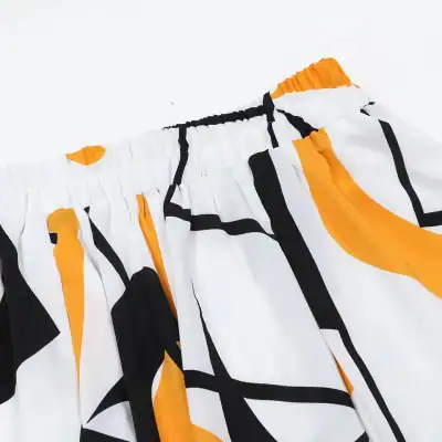Colorful shorts with bold black, white, and orange geometric patterns, featuring an elastic waistband, perfect for casual wear and summer fashion statements.