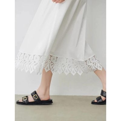 Elegant white dress featuring intricate lace detailing at the hem, perfect for stylish occasions and casual outings. Showcasing a modern, breezy design for women seeking fashionable comfort.