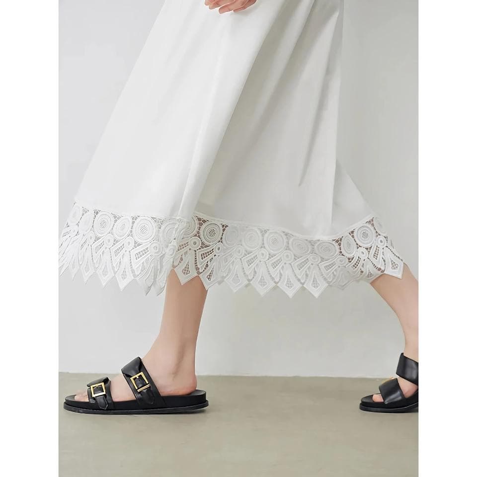 Elegant white dress featuring intricate lace detailing at the hem, perfect for stylish occasions and casual outings. Showcasing a modern, breezy design for women seeking fashionable comfort.