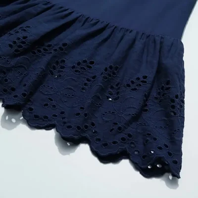 Navy blue eyelet lace skirt featuring intricate floral cutout design and scalloped edge, perfect for fashionable women seeking chic and comfortable clothing options.