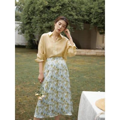 Image of a woman wearing a stylish floral skirt and a yellow blouse, showcasing trendy opt for summer fashion from Monalisa Store. Perfect for a chic, casual look.