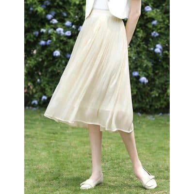 Stunning feminine midi pleated skirt in ivory, perfect for spring and summer fashion. Flowy, stylish, and versatile for casual or dressy occasions.