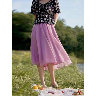 Bright pink flowy skirt paired with a floral blouse creates a fashionable look ideal for outdoor casual wear and picnics with friends.
