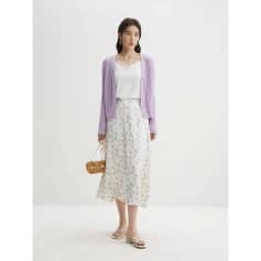 Stylish women's outfit featuring a white top, lavender cardigan, printed midi skirt, and chic accessories for a trendy, sophisticated appearance.