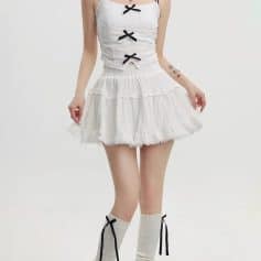 Delicate white lace dress featuring black bow accents, perfect for stylish occasions.