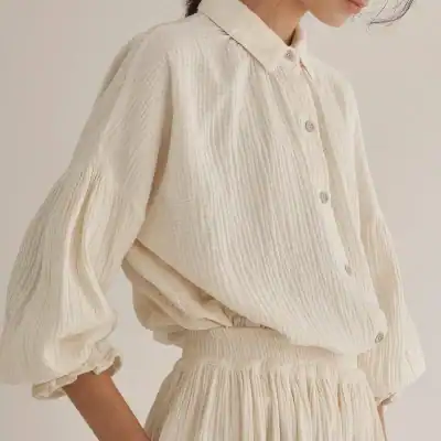 Stylish beige blouse with textured fabric, button-up front, and puff sleeves. Perfect for casual or semi-formal outfits, available at Monalisa Store.