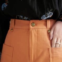 Stylish orange skirt with gold buttons, featuring a high waist design and large front pocket, ideal for professional or casual wear, available at Monalisa Store.