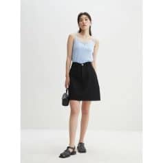 Stylish casual women's outfit for everyday wear, featuring a light blue sleeveless top paired with a black denim skirt, accessorized with sandals and a small handbag. Perfect for a modern, chic look.