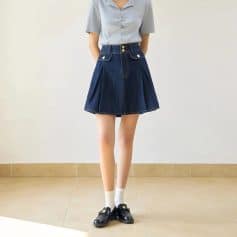 A stylish high-waisted denim skirt featuring pleats, front buttons, and side pockets, perfect for casual or semi-formal outfits. Made from durable denim fabric for comfort and fashion.