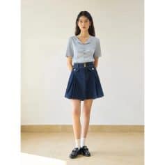 Young woman wearing stylish casual outfit with denim skirt and blouse, perfect for trendy office, school, or casual outings.