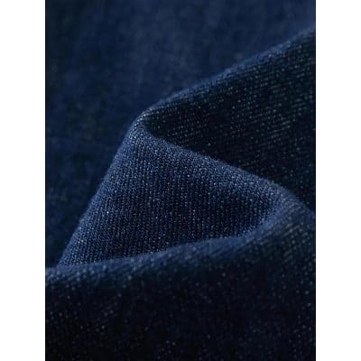 Close-up of high-quality dark blue denim fabric with tiny white threads, ideal material for stylish eyewear frames, accessories, and fashion apparel in optical retail.