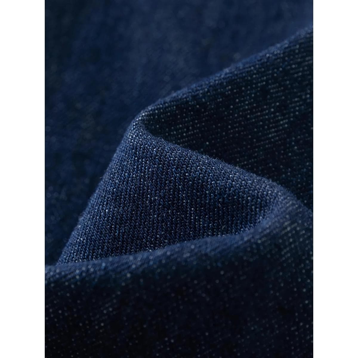 Close-up of high-quality dark blue denim fabric with tiny white threads, ideal material for stylish eyewear frames, accessories, and fashion apparel in optical retail.