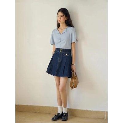 A trendy denim skirt and light blue blouse combination for women, showcasing casual elegance with gold accents. Ideal for modern fashion enthusiasts interested in stylish, comfortable clothing.
