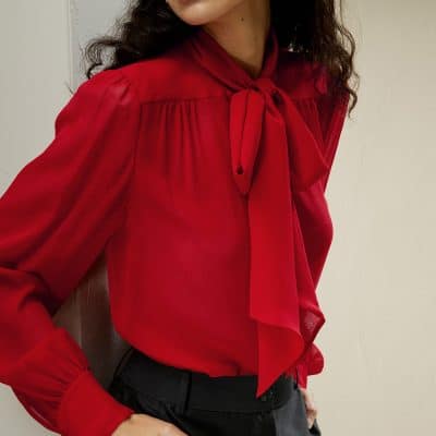 Fashionable women's red blouse featuring a stylish bow tie neckline and long sleeves, perfect for office wear or social occasions. Crafted for comfort and elegance.