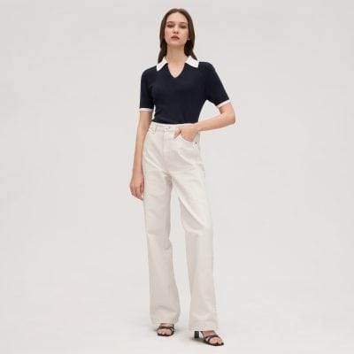 Alt text: Stylish woman wearing navy sweater with white collar and beige wide-leg jeans, showcasing trendy casual fashion.