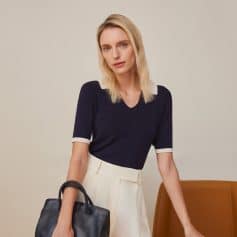 A woman holding a stylish black handbag, showcasing fashionable accessories available at Monalisa Medical eyewear store. Perfect for sophisticated look and optical needs.