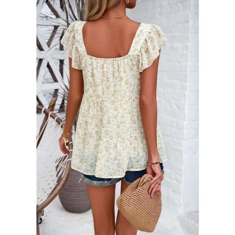 Light-colored floral women's summer blouse with ruffled sleeves, perfect for casual and vacation wear.