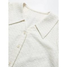 Elegant white textured blouse with delicate details for women.