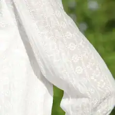 Soft white embroidered blouse with intricate floral and geometric patterns, perfect for stylish and comfortable wear.