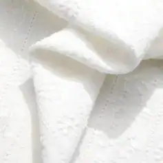 Close-up of a luxurious white lace blouse showcasing intricate textured patterns and delicate fabric, perfect for sophisticated fashion statements.