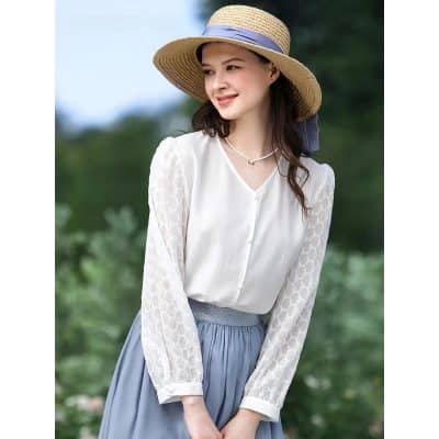Wide-brim straw sun hat with navy ribbon, perfect for outdoor fashion and sun protection, complemented by stylish jewelry.
