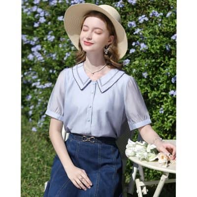 A stylish, light blue summer blouse with a decorative collar, perfect for outdoor wear and sun protection.