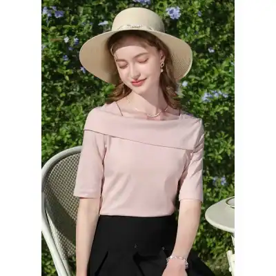 Stylish straw hat, jewelry, and fashionable blouse for women in outdoor garden setting.
