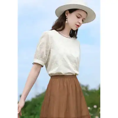 Stylish women's fashion blouse with delicate embroidery and short puff sleeves, perfect for summer or casual outings.