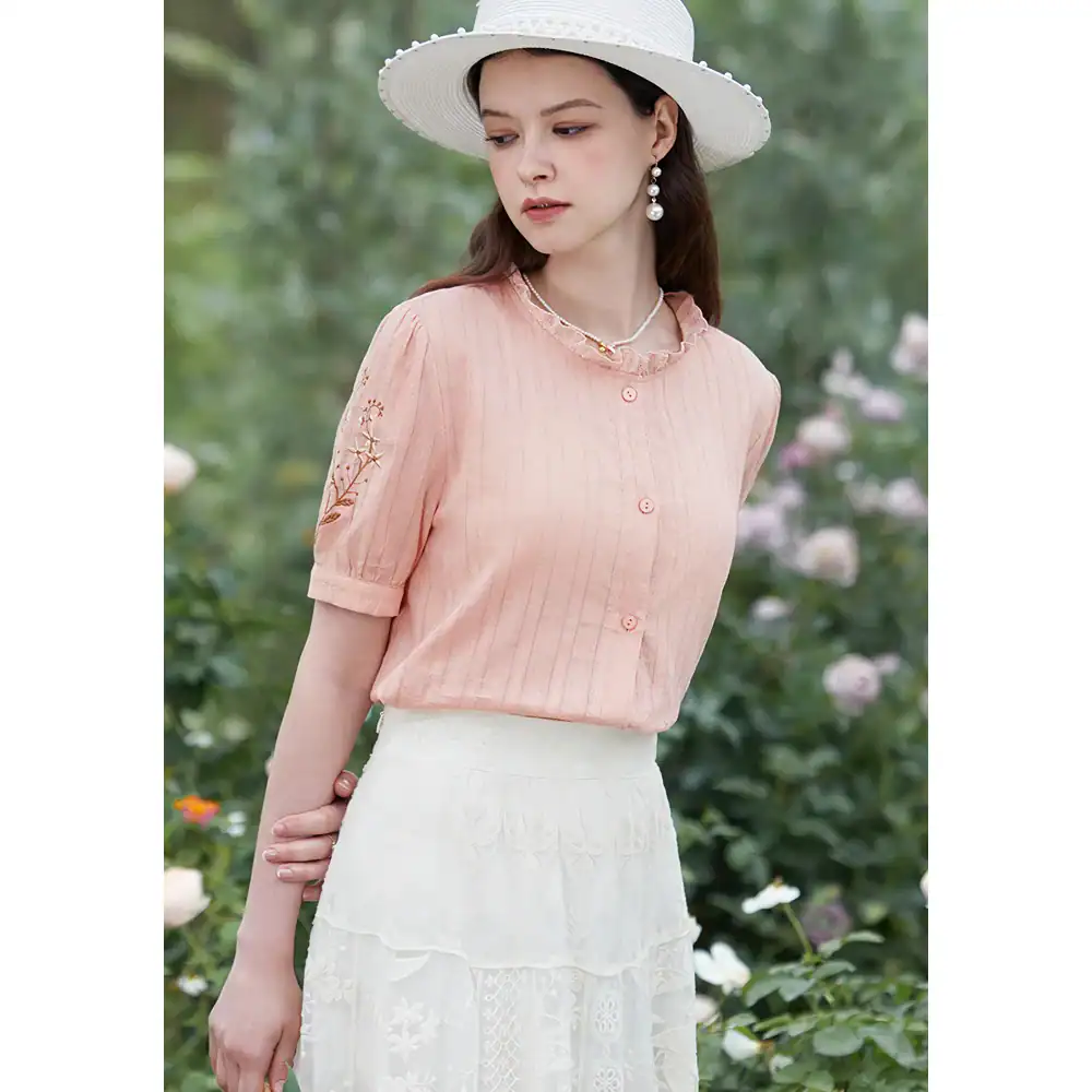 Pink women's summer blouse with embroidered sleeves and button details, ideal for stylish summer outfits, casual and semi-formal wear, made from breathable fabric for all-day comfort.