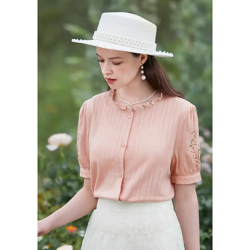 Stylish women’s blouse featuring pastel pink color with embroidered sleeve details, perfect for summer wear and elegant occasions, available at Monalisa Store.