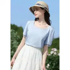 Elegant woman wearing summer hat, light blue blouse, and white skirt outdoor shot, perfect for showcasing summer fashion, sun protection, and casual style.
