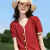 Beautiful red summer dress featuring lace trim and floral button details, perfect for warm-weather occasions and outdoor outings.