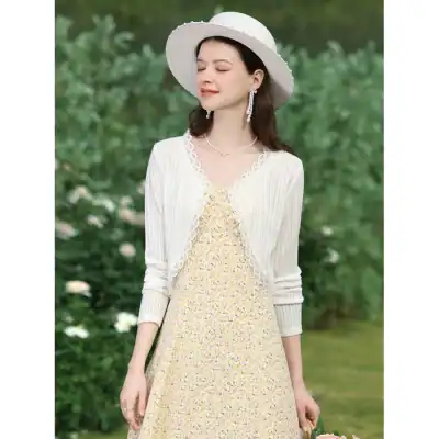 Stylish women's dress paired with a white cardigan and wide-brim hat, perfect for outdoor events. Featuring floral patterns and delicate lace details, ideal for summer fashion enthusiasts.