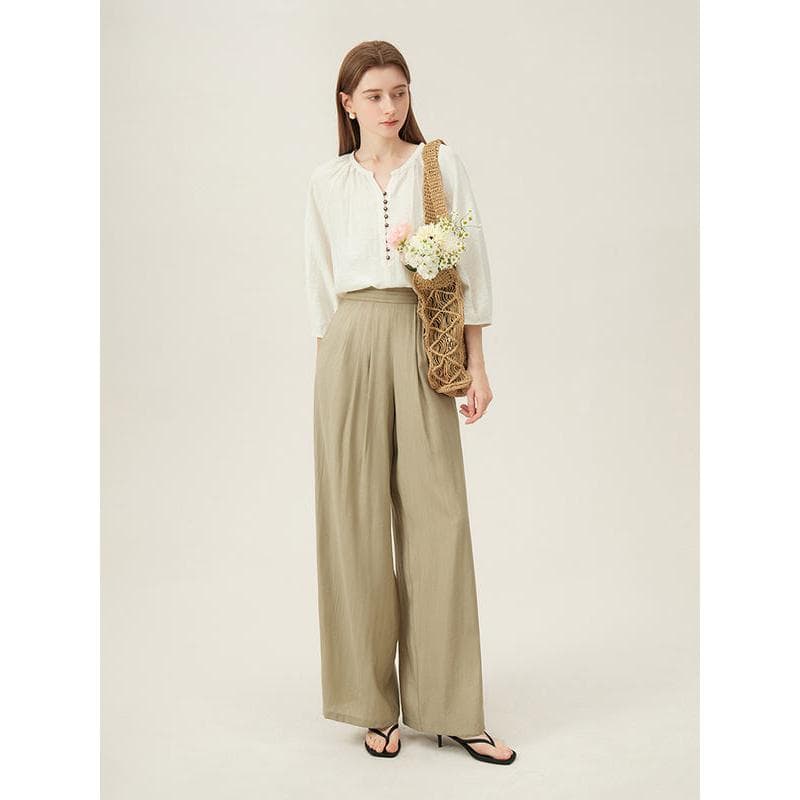 Stylish outfit featuring a white blouse and beige wide-leg trousers, perfect for casual or professional wear.