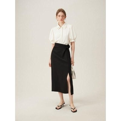 Stylish woman in white blouse and black midi skirt, perfect for office or formal occasions, showcasing contemporary fashion and professional style.