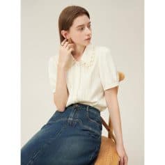 Fashionable women's white blouse with lace collar, perfect for office or casual wear, paired with denim jeans for a chic appearance.