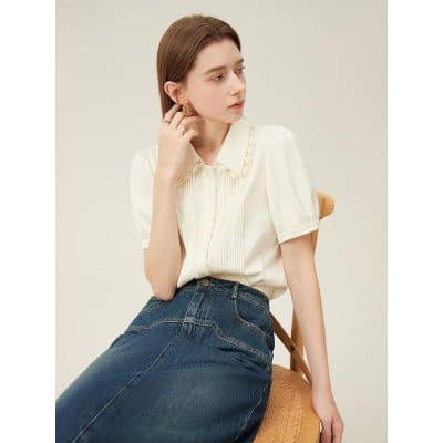 Fashionable women's white blouse with lace collar, perfect for office or casual wear, paired with denim jeans for a chic appearance.