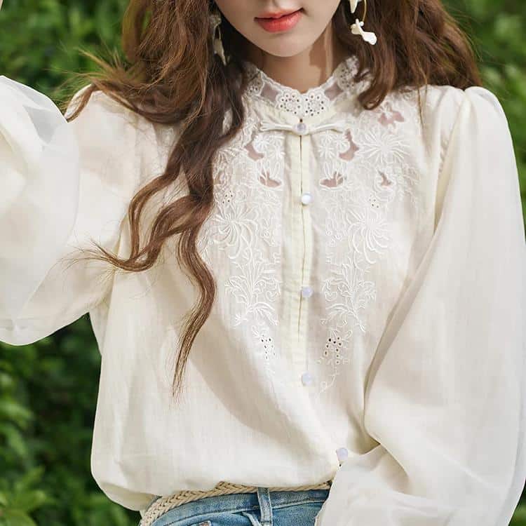 Stylish women's cream blouse with intricate lace embroidery, button-up front, and puff sleeves. Perfect for casual or semi-formal occasions, enhancing your fashion statement.