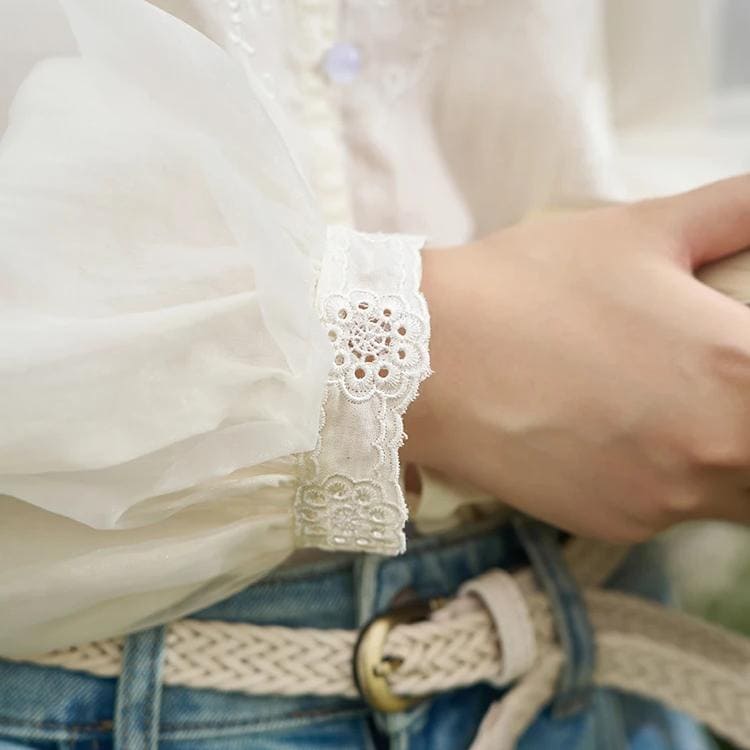 Close-up of a white blouse sleeve featuring delicate lace embroidery, emphasizing style and craftsmanship. Perfect for fashion-conscious individuals seeking elegant women’s apparel at Monalisa Store.