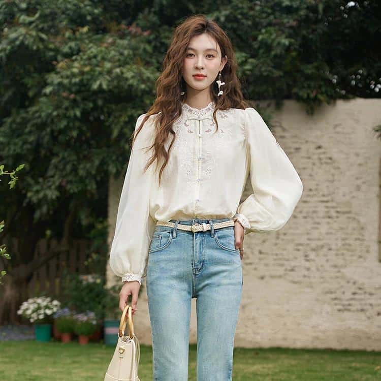 A fashionable woman wearing a stylish beige blouse and light denim jeans, perfect for casual and everyday wear. The outdoor backdrop highlights trendy, comfortable clothing suitable for modern women shopping at Monalisa Store.