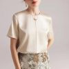 Luxurious satin blouse with pearl accents, perfect for sophisticated occasions and office wear. Designed for style and comfort, making it an essential addition to your wardrobe.