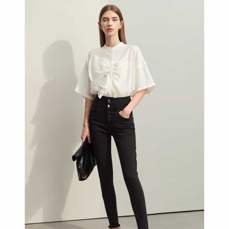 Stylish woman wearing a white blouse and black high-waisted pants, perfect for business or casual wear.