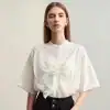 Stylish white blouse with satin finish, ruffle embellishments, and button-up front, perfect for fashionable office wear or casual outings.