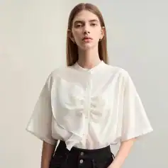 Stylish white blouse with satin finish, ruffle embellishments, and button-up front, perfect for fashionable office wear or casual outings.