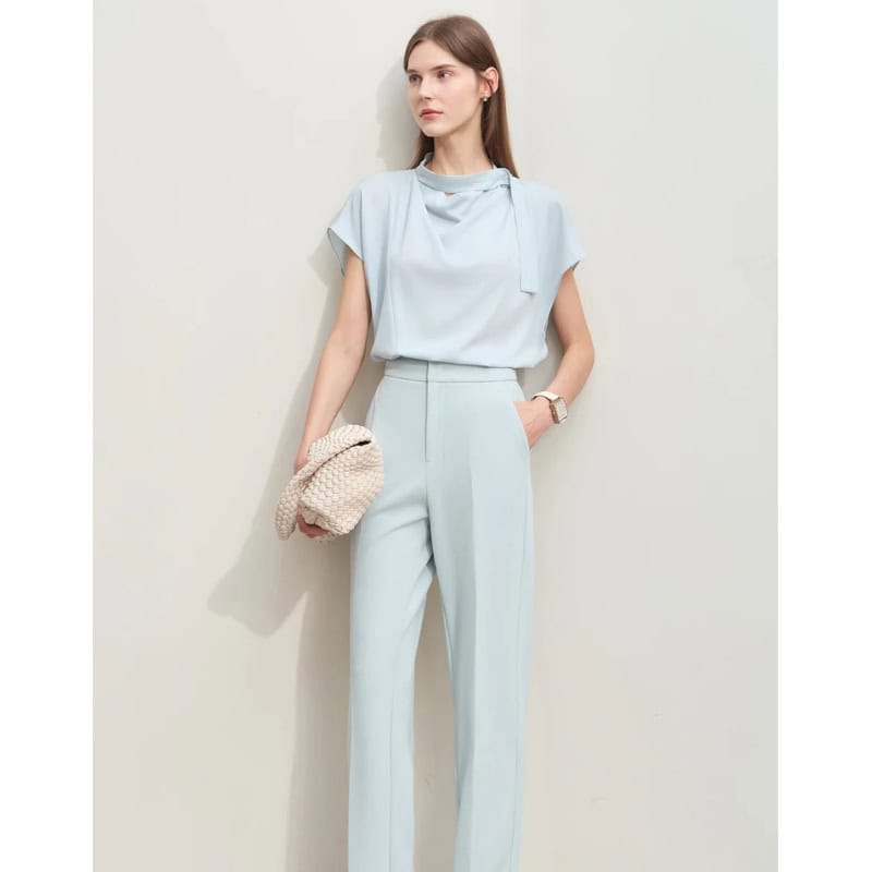 Elegant light blue women's formal suit with matching tailored trousers and a chic top, perfect for professional and stylish occasions.