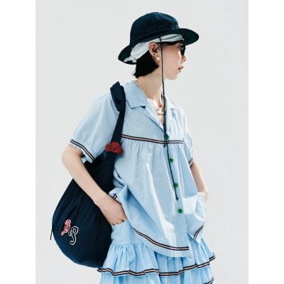 Woman in fashionable outfit carrying a backpack, wearing sunglasses, and a sunhat, representing eye care and vision enhancement products available at Monalisa Medical Store.