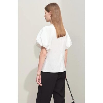 A stylish white blouse with voluminous puff sleeves, perfect for casual or office wear. Made from high-quality fabric, this top offers a chic and comfortable fit for women seeking fashionable apparel.