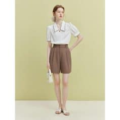 Beautiful casual outfit for women with stylish white blouse and high-waisted brown shorts perfect for summer wear.